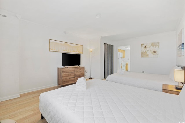 bedroom featuring ornamental molding and light hardwood / wood-style flooring