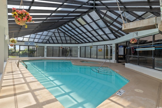 view of pool featuring glass enclosure and an indoor hot tub