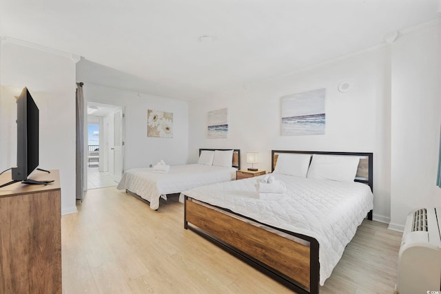 bedroom with light hardwood / wood-style flooring and ornamental molding