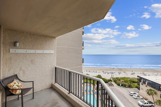 balcony featuring a beach view and a water view