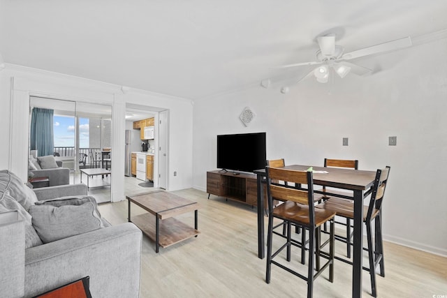 living room featuring ceiling fan, ornamental molding, and light wood-type flooring