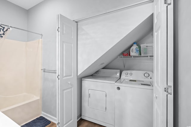 clothes washing area with dark hardwood / wood-style floors and washer and dryer