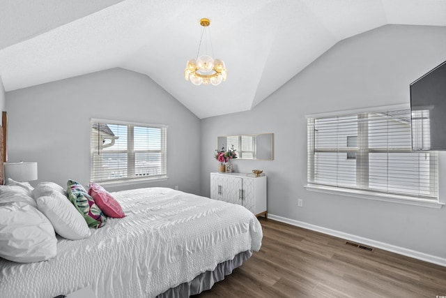 bedroom with an inviting chandelier, dark hardwood / wood-style flooring, and vaulted ceiling