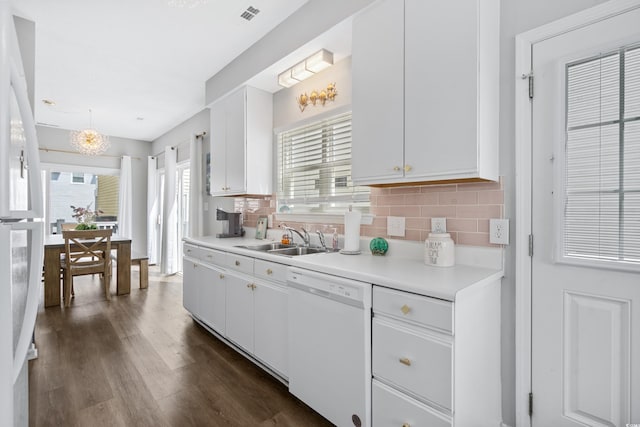 kitchen with tasteful backsplash, sink, white appliances, and white cabinets