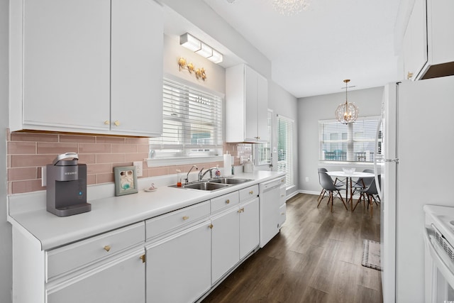 kitchen featuring sink, white cabinets, dark hardwood / wood-style flooring, hanging light fixtures, and white appliances