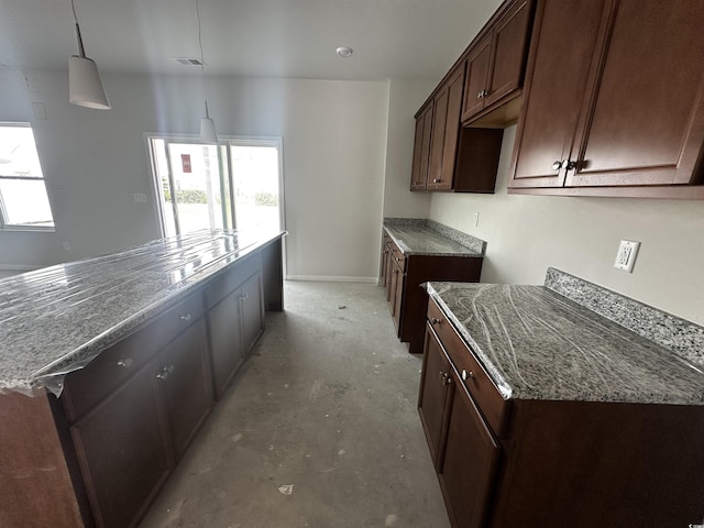 911 Agostino Dr, Myrtle Beach, SC 29579 - kitchen featuring unfinished concrete flooring, stone counters, baseboards, dark brown cabinets, and decorative light fixtures