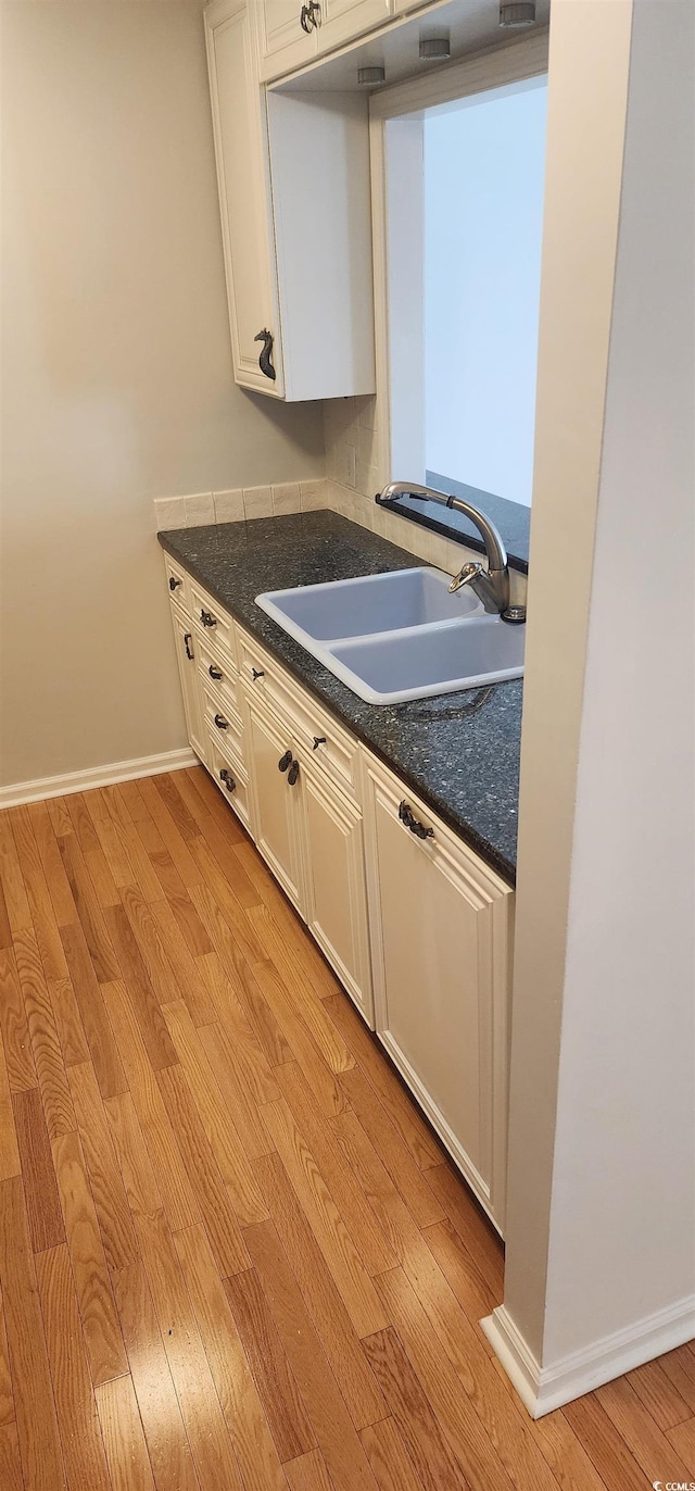 kitchen featuring sink, light hardwood / wood-style floors, and white cabinets