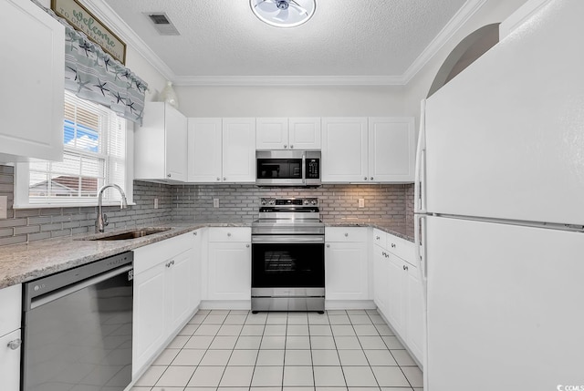 kitchen featuring sink, crown molding, appliances with stainless steel finishes, white cabinetry, and decorative backsplash