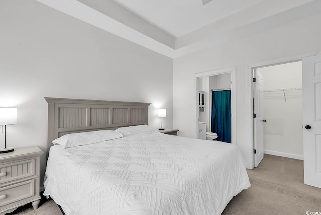 carpeted bedroom with connected bathroom, a spacious closet, and a closet