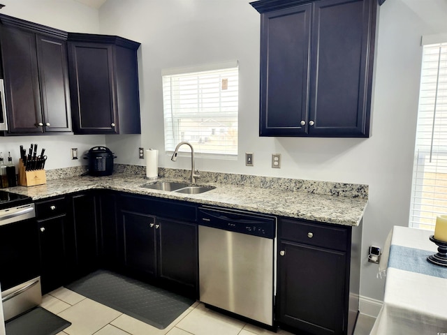 kitchen with appliances with stainless steel finishes, sink, light tile patterned floors, and plenty of natural light