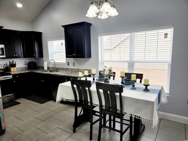 kitchen with sink, vaulted ceiling, light tile patterned floors, electric range, and pendant lighting