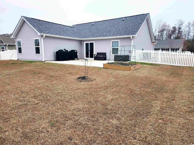 rear view of house with a patio and a lawn