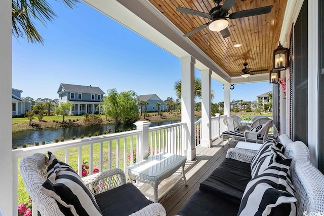 wooden deck featuring a porch, a water view, and ceiling fan