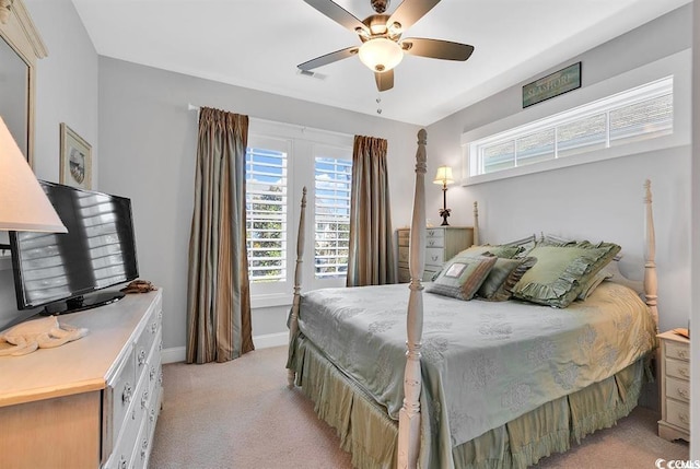 bedroom with multiple windows, light colored carpet, and ceiling fan