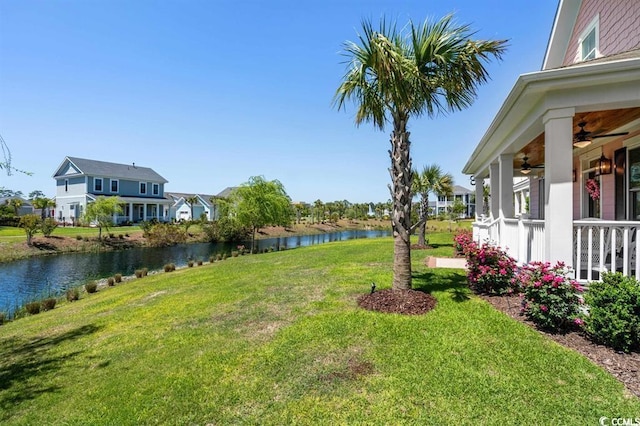 view of yard featuring a water view and ceiling fan