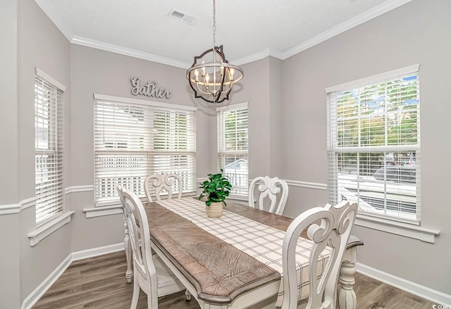 dining room with a notable chandelier, baseboards, and wood finished floors