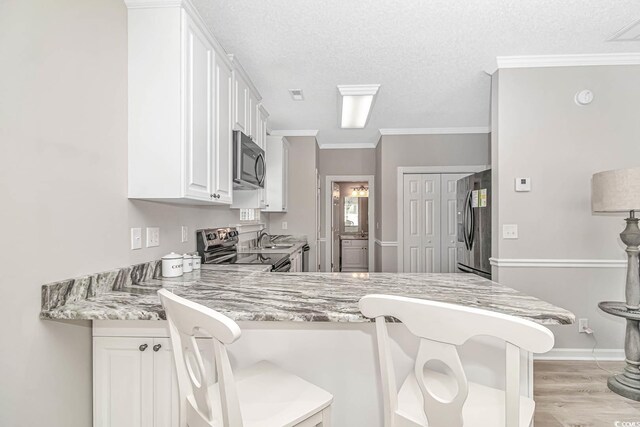 6001-1383 S Kings Hwy, Myrtle Beach, SC 29575 - kitchen featuring appliances with stainless steel finishes, a peninsula, ornamental molding, a breakfast bar, and white cabinetry