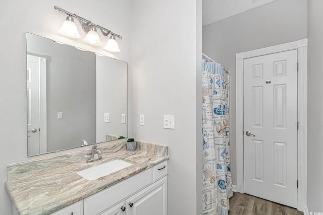 full bathroom with curtained shower, wood finished floors, and vanity