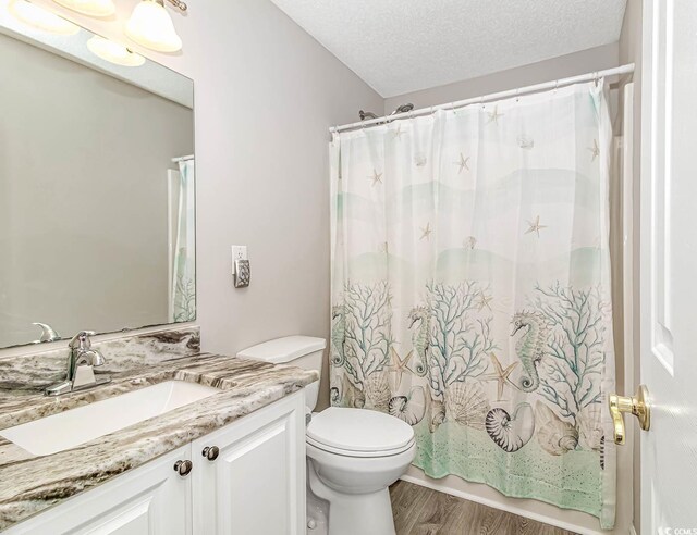 6001-1383 S Kings Hwy, Myrtle Beach, SC 29575 - bathroom featuring vanity, a textured ceiling, toilet, and wood finished floors