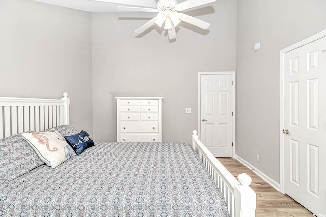 bedroom featuring light wood finished floors, baseboards, and a ceiling fan