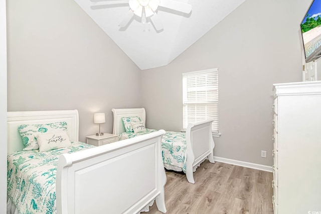 bedroom featuring light wood-style flooring, baseboards, vaulted ceiling, and a ceiling fan