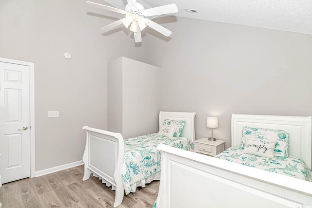 bedroom with vaulted ceiling, baseboards, a ceiling fan, and light wood-style floors