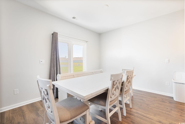 dining room featuring visible vents, baseboards, and wood finished floors