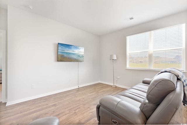 living area with visible vents, baseboards, and light wood-style floors