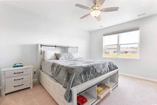 bedroom featuring visible vents, baseboards, light colored carpet, and ceiling fan