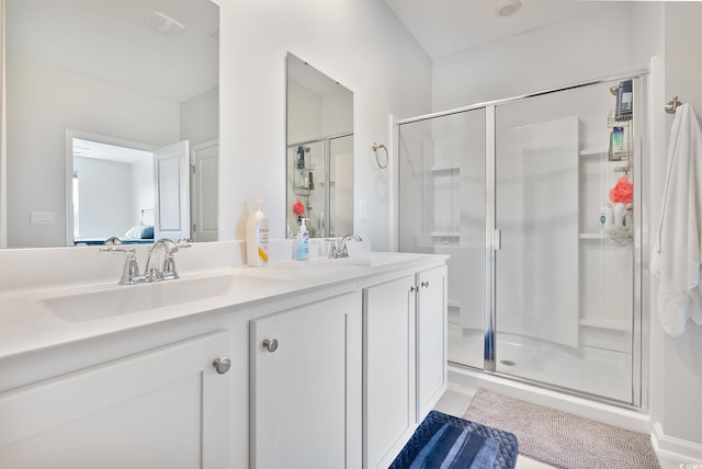 full bathroom featuring double vanity, visible vents, a shower stall, and a sink