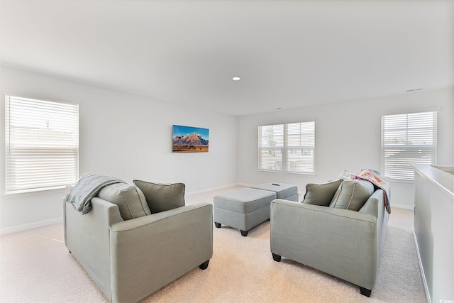 living area with light carpet and baseboards