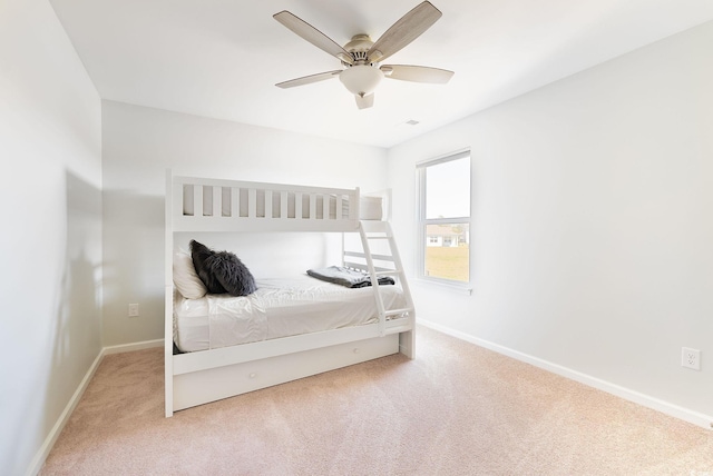 carpeted bedroom with ceiling fan and baseboards