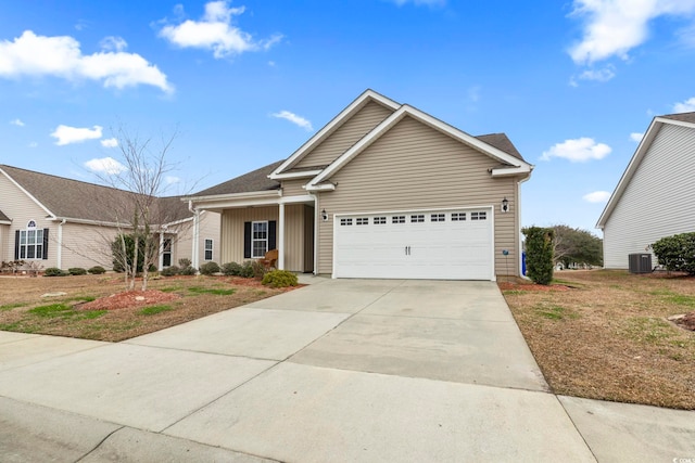 view of front of house with an attached garage, central AC, and driveway