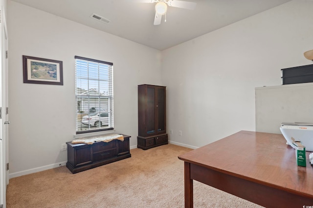 office space with visible vents, baseboards, light colored carpet, and ceiling fan