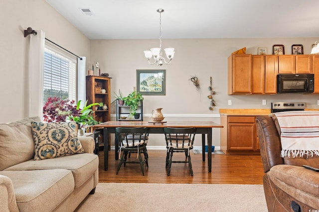 kitchen featuring visible vents, a notable chandelier, open floor plan, stainless steel electric range, and black microwave