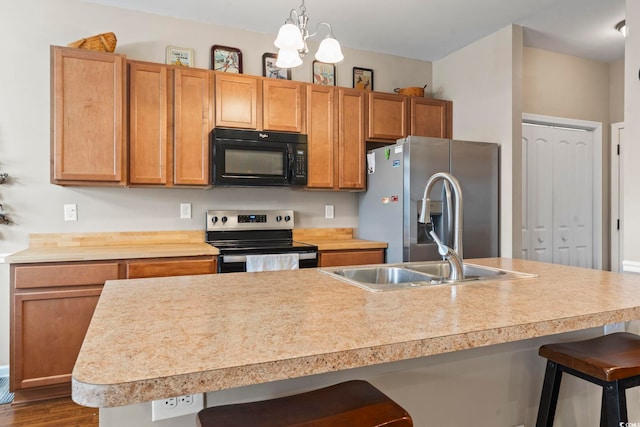 kitchen with a sink, light countertops, a kitchen breakfast bar, and stainless steel appliances