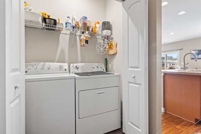 laundry area featuring a sink, wood finished floors, recessed lighting, separate washer and dryer, and laundry area