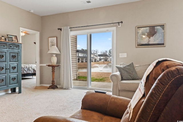 living area featuring a ceiling fan, baseboards, and carpet floors