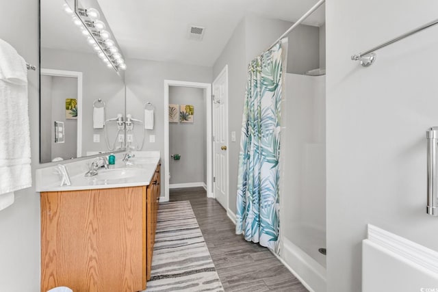 bathroom with hardwood / wood-style floors, vanity, and curtained shower