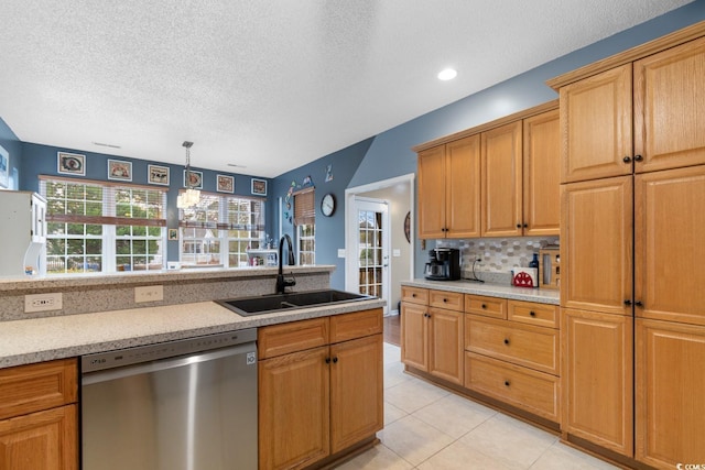 kitchen featuring pendant lighting, sink, decorative backsplash, stainless steel dishwasher, and light tile patterned floors