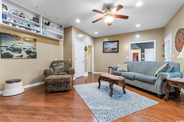 living room with ceiling fan and dark hardwood / wood-style flooring