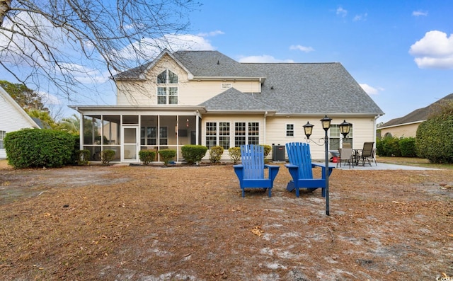 rear view of property with a sunroom, central AC unit, and a patio area