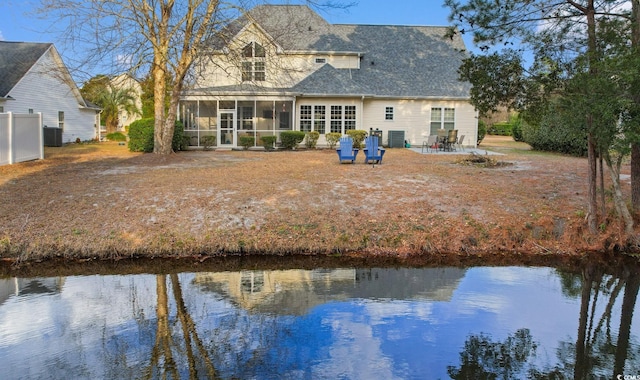 back of property with cooling unit, a patio area, a sunroom, and a water view