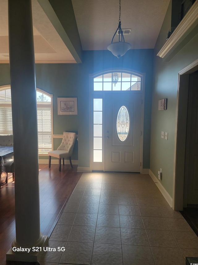foyer with baseboards and dark tile patterned flooring