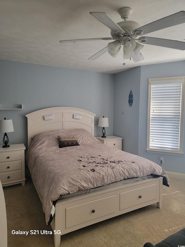 bedroom with a textured ceiling, carpet floors, and a ceiling fan