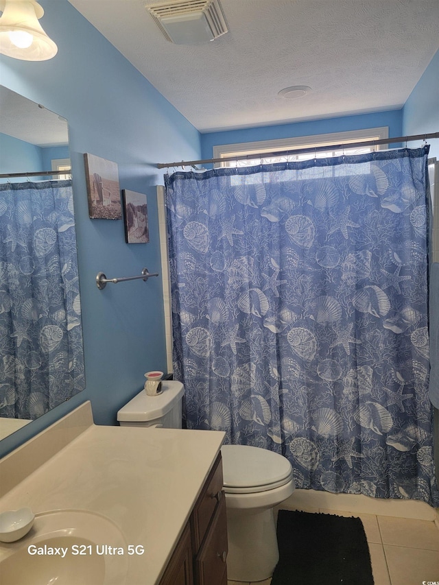 bathroom with visible vents, toilet, tile patterned floors, a textured ceiling, and vanity