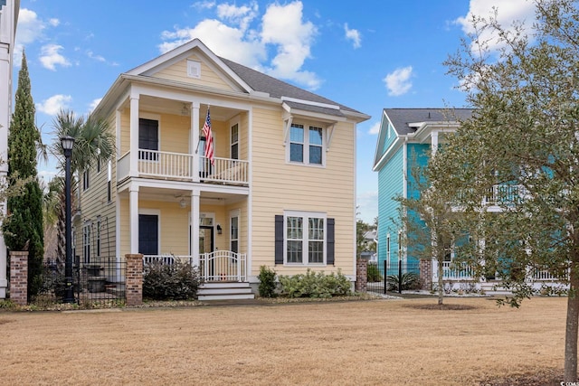 view of front facade with a front yard, a balcony, and a porch