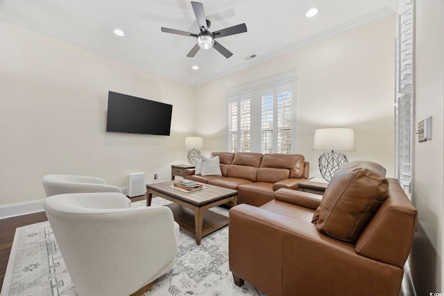 living room with hardwood / wood-style flooring, ceiling fan, and ornamental molding