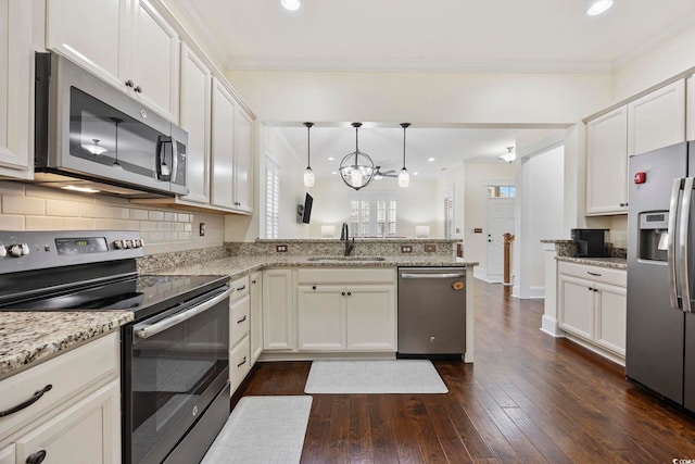 1188 Peterson St, Myrtle Beach, SC 29577 - kitchen with stainless steel appliances, a sink, a peninsula, dark wood-type flooring, and ornamental molding