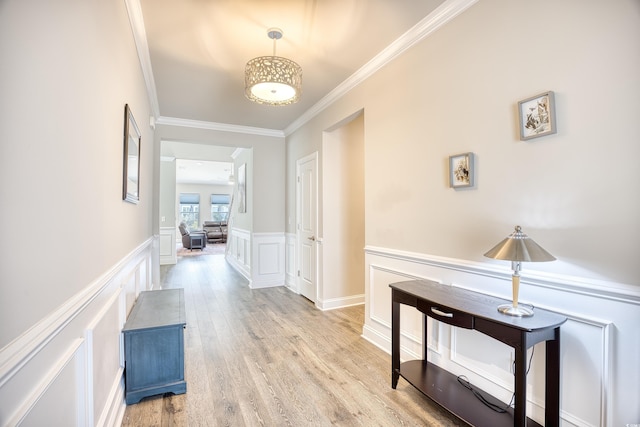 hallway with ornamental molding and light wood-type flooring